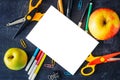 Back to school concept. White blank sheet isolated with two apples and school supplies on table top view Royalty Free Stock Photo