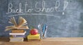 Back to school after the coronavirus lockdown, education supplies, books, pens, message on blackboard Royalty Free Stock Photo