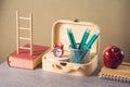 Back to school creative concept with pencils, apple, books and suitcase box. Modern still life composition Royalty Free Stock Photo