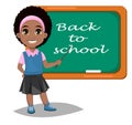 Back to school. Cute Afro-American girl standing near blackboard