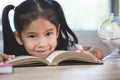 Cute asian child girl with a book smiling in the classroom Royalty Free Stock Photo