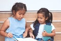 Cute asian child girl and her sister reading a book Royalty Free Stock Photo