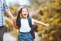 Cute asian pupil girl with backpack holding her mother