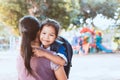 Cute asian pupil girl with backpack hugging her mother Royalty Free Stock Photo