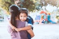 Cute asian pupil girl with backpack hugging her mother Royalty Free Stock Photo
