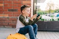 Back to school. Cute child with backpack, holding mobile phone, playing with cellphone. School boy pupil with bag Royalty Free Stock Photo