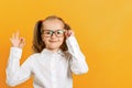 Back to school. Cute little girl in glasses shows a sign approx. The concept of success and education Royalty Free Stock Photo