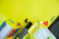 Back to school. Distance learning. Stationery with medical masks and a tablet on a yellow background. Flat lay. Copy space