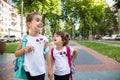 Back to school education concept with girl kids, elementary students, carrying backpacks going to class