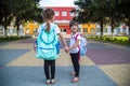 Back to school education concept with girl kids, elementary students, carrying backpacks going to class