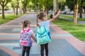 Back to school education concept with girl kids, elementary students, carrying backpacks going to class