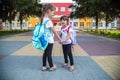 Back to school education concept with girl kids, elementary students, carrying backpacks going to class