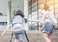 Back to school education concept with girl kids elementary students carrying big backpacks going to class holding hand in hand