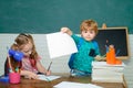 Back to school - education concept. Little ready to study. Funny little kids pointing up on blackboard. Kids with a book Royalty Free Stock Photo