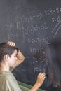 Schoolboy solving a problem on a blackboard. Royalty Free Stock Photo