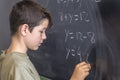 Schoolboy solving a problem on a blackboard. Royalty Free Stock Photo