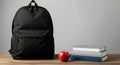 Back to School Essentials Black Backpack Apple and Books on Wooden Desk Royalty Free Stock Photo