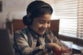 Back to school, but first a snack. an adorable little boy using a laptop and headphones while completing a school Royalty Free Stock Photo