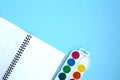 Back to school flat lay with watercolor and open notepad on blue background Royalty Free Stock Photo