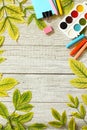 Back to school. Flatlay background. Table with autumn leaves and different school supplies, stationery, pencils.