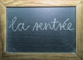 Back to school in french text `la rentrÃÂ©e` concept written on chalkboard with wooden frame