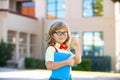 Back to school. Funny little boy in glasses at school. Child from elementary school with book and bag. Education child. Royalty Free Stock Photo