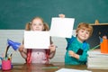 Back to school. Funny little kids pointing up on blackboard - school concept. Education. Paper copy space. Royalty Free Stock Photo