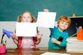 Back to school. Funny little kids pointing up on blackboard - school concept. Education. Paper copy space. Royalty Free Stock Photo