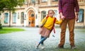 Back to school. Funny portrait child. Pupil girl of primary school go hand in hand with dad. Teacher and cute schoolgirl