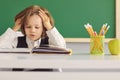 Back to school. Funny schoolboy is reading a book while sitting at the table for the first time at school on the Royalty Free Stock Photo