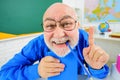 Back to school. Funny teacher with notebook pointing finger up. Happy tutor in glasses with copybook in classroom Royalty Free Stock Photo