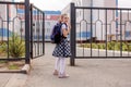 Back to school. Girl in school uniform go to school with backpack behind their backs. Beginning of lessons. First day of Royalty Free Stock Photo