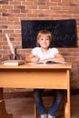 Back to school: girl is sitting at a school desk and studying math. The child is doing homework. Preschool education, vertical Royalty Free Stock Photo