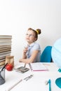 Back to school: Girl sitting at her desk meditates with a pencil in her hand.