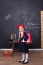 Back to school! A girl stands in school with a red backpack. Responds to the lesson. School concept. On the blackboard in Ukrainia Royalty Free Stock Photo