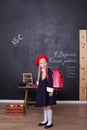 Back to school! A girl stands in school with a red backpack. Responds to the lesson. School concept. On the blackboard in Ukrainia Royalty Free Stock Photo