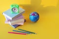 Back to school, globe, alarm clock, stack of books and pencils on bright background Royalty Free Stock Photo