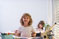 Back to school. Happy cute child is sitting at a desk indoors. Cild is learning in class.