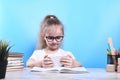 Back to school .Happy cute industrious child is sitting at a desk indoors.Uses a mobile phone for learning.Kid is learning in Royalty Free Stock Photo