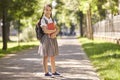Back to school. Happy schoolgirl smiles while standing on the road to school in the morning. Royalty Free Stock Photo