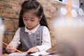 Back to school. Happy smiling pupil drawing at the desk. Cute little preschooler child drawing at home. Kid girl drawing with penc Royalty Free Stock Photo