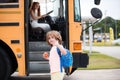 Back to school and happy time. Education: Smiling Elementary Student Ready To Board Bus. Royalty Free Stock Photo