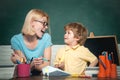 Back to school and happy time. Funny little child and young female teacher having fun on blackboard background. Teachers Royalty Free Stock Photo