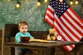 Back to school or home schooling. Happy independence day of the usa. Little boy eat bread at American flag at knowledge Royalty Free Stock Photo