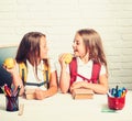 Back to school and home schooling. Little girls eat apple at lunch break. School time of girls. Friendship of small Royalty Free Stock Photo