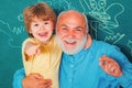 Back to school. Hug and embrace - Grandfather and grandson. Teacher helping young boy with lesson. Grandfather. Royalty Free Stock Photo