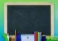 Back to school image of school or office supplies in a flat lay design with a blackboard in the center Royalty Free Stock Photo