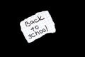 Back to school inscription on paper on black background Royalty Free Stock Photo