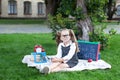 Back to school.  kid is ready for school. smart child little girl in glasses with school supplies: a school board, books, a magnif Royalty Free Stock Photo