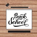 Back to school lettering hand written in a notebook. Wooden texture background and stationery. Vector template for advertising Royalty Free Stock Photo